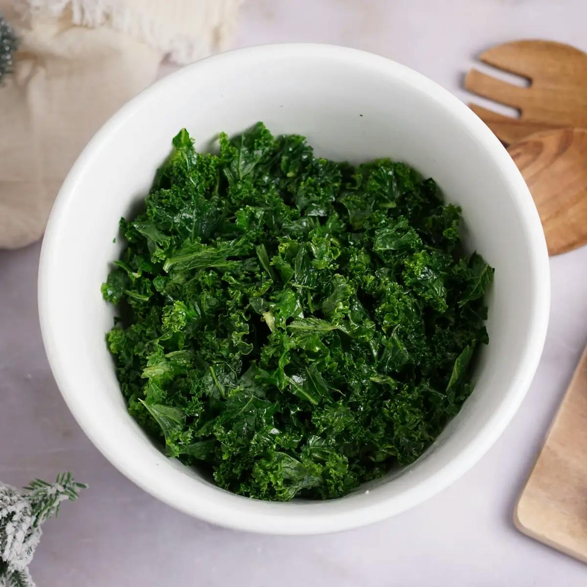 Massaging kale until soft, as part of a Thanksgiving salad recipe.