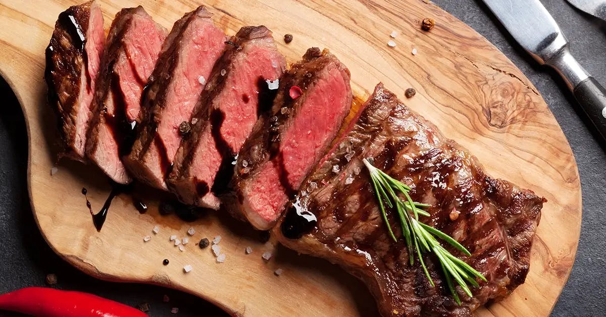 Sliced meat resting on a cutting board after barbecuing.