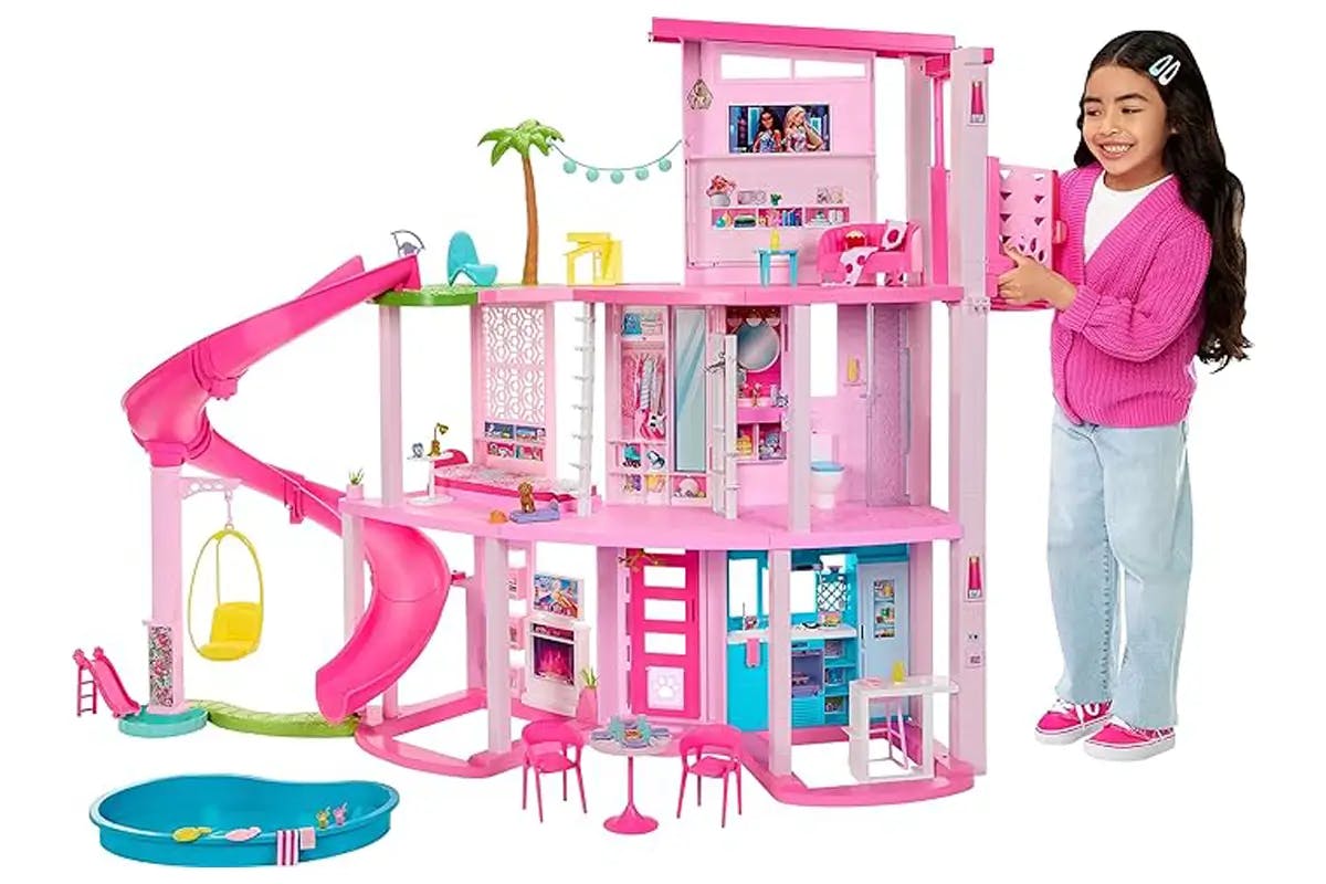 Young girl playing with Barbie Dreamhouse 2023, as shown in Barbie the Movie.